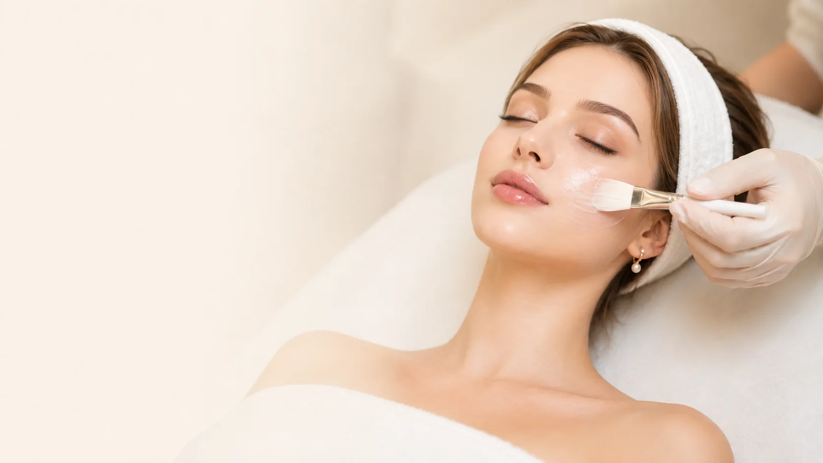 Woman receiving a facial treatment as product is applied to her cheek
