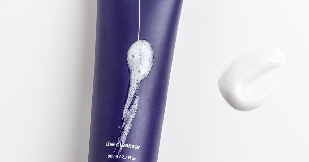 Calm woman applying serum at night, soft warm bathroom lighting