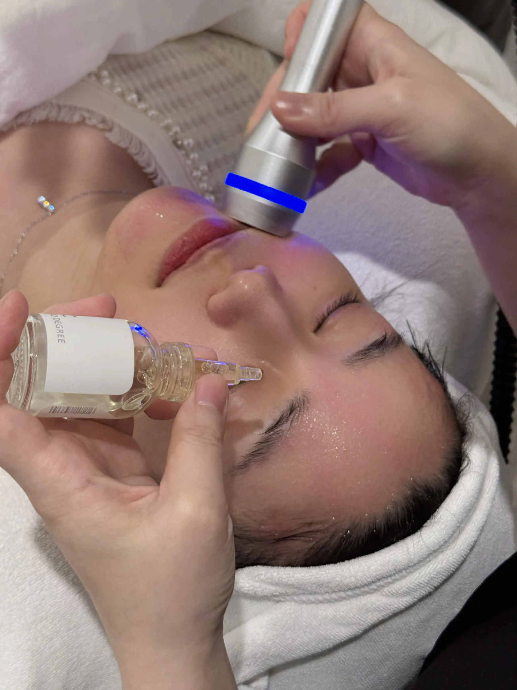 Client receiving a hydration facial with serum and a treatment device