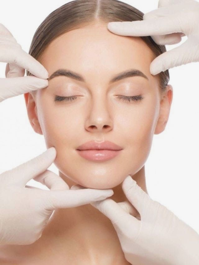 Gloved hands gently assessing facial skin